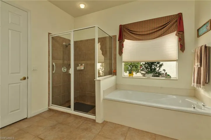 Bathroom featuring tile patterned flooring and plus walk in shower