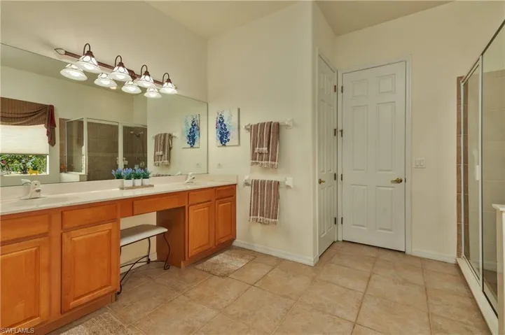 Bathroom with tile patterned flooring, vanity, and an enclosed shower