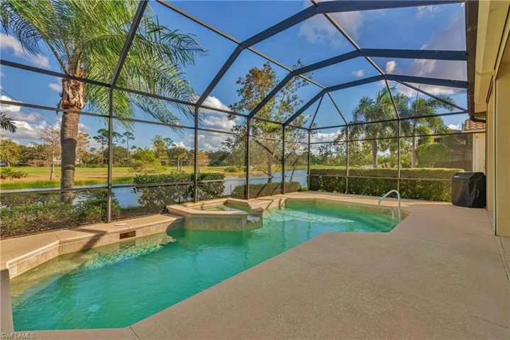 View of pool featuring a lanai, an in ground hot tub, and a water view