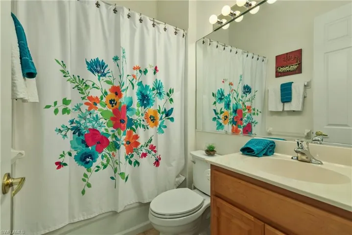 Full bathroom featuring vanity, toilet, and shower / bathtub combination with curtain