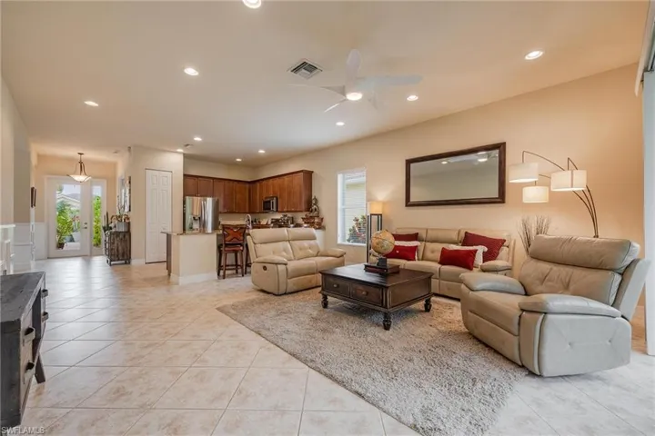 Living room with ceiling fan and light tile floors