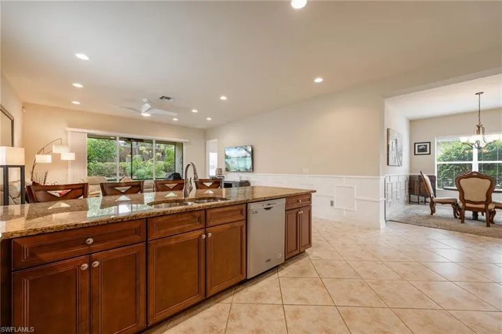 Kitchen with decorative light fixtures, sink, dishwasher, and a wealth of natural light