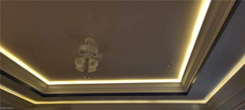 Detailed view of a tray ceiling, ceiling fan, and crown molding