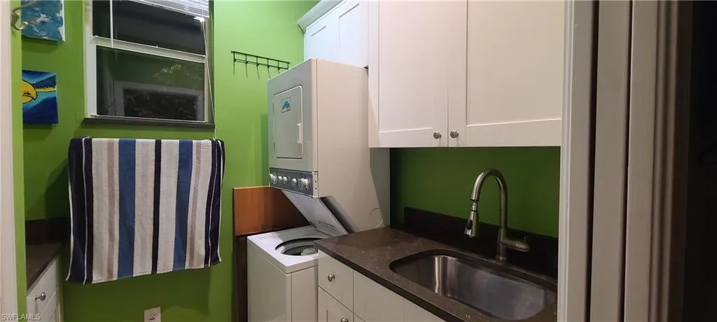 Laundry room featuring estacked washer and dryer and cabinet space