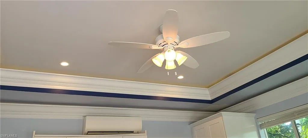 Detailed view of ornamental molding, ceiling fan, a wall mounted AC, and recessed lighting