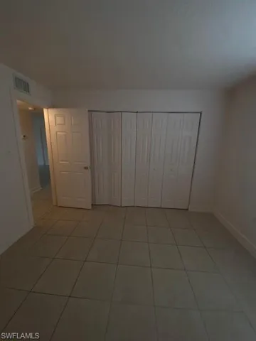 Unfurnished bedroom with a closet and tile patterned flooring