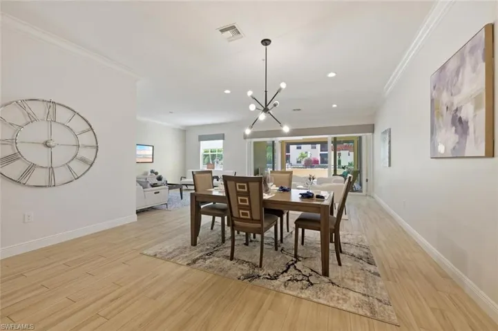 Dining area with wood-finish flooring, recessed lighting, and crown molding