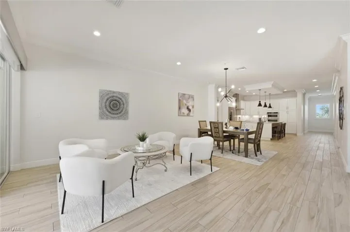 Open-concept interior featuring wood-finish flooring, recessed lighting, and crown molding