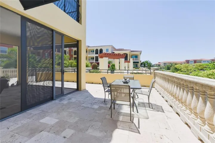 Expansive outdoor terrace featuring paver flooring, a balustrade railing, and sliding glass doors