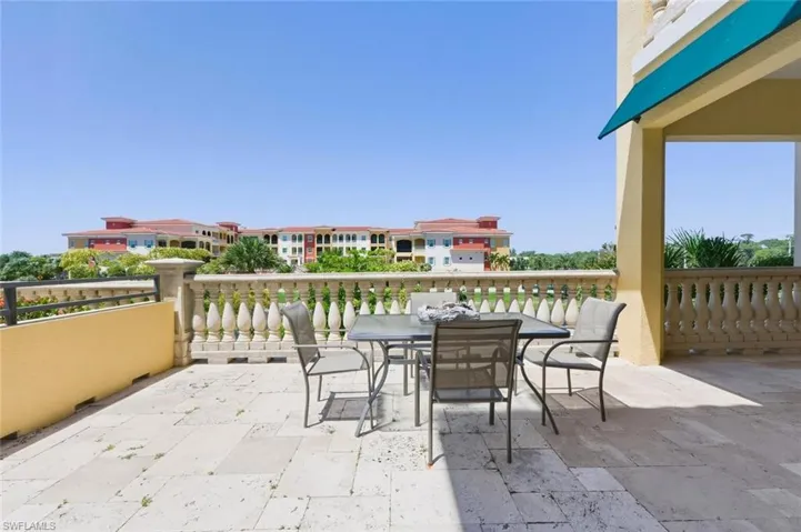 Expansive outdoor patio featuring light-toned tile flooring and an ornate balustrade railing