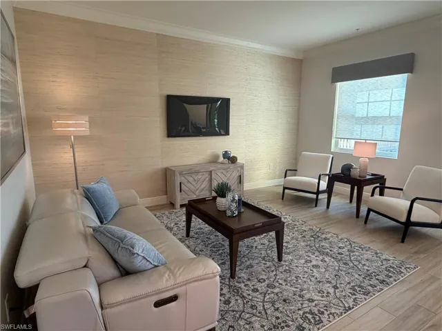 Living room with light wood-type flooring and ornamental molding
