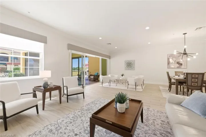 Open-concept living area featuring wood-finish flooring, recessed lighting, and a contemporary chandelier