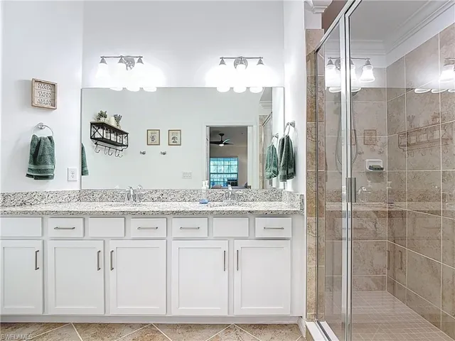 Bathroom with a shower stall, vanity, ensuite bathroom, a ceiling fan, and light tile patterned floors