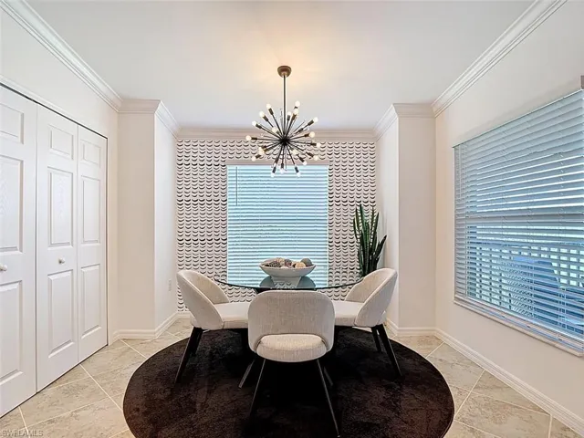 Dining area featuring a chandelier, ornamental molding, and healthy amount of natural light