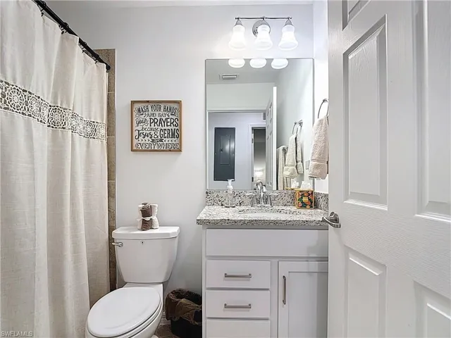Full bathroom featuring vanity, a shower with curtain, and electric panel