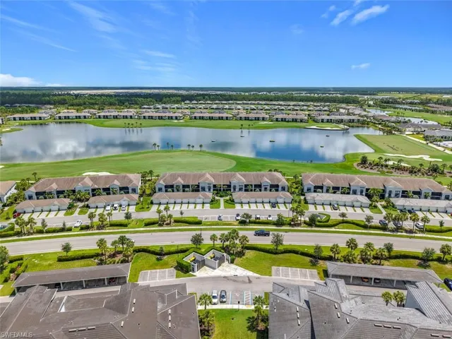 Aerial view of residential area featuring a large body of water and a golf club