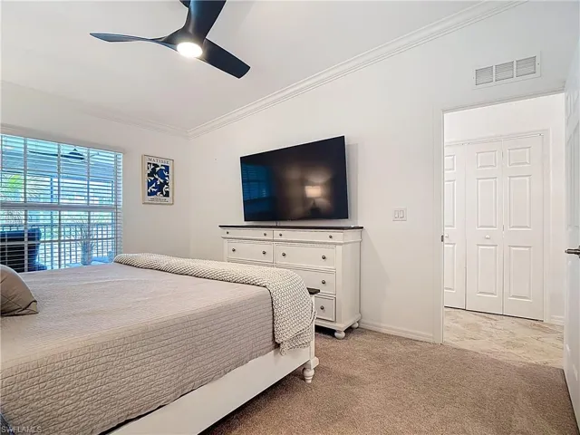 Bedroom featuring crown molding, light colored carpet, and ceiling fan