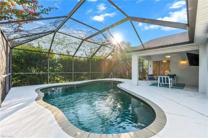 Swimming pool featuring a sunroom, glass enclosure, a patio, and a ceiling fan