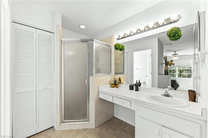 Full bath with a closet, vanity, a stall shower, and connected bathroom