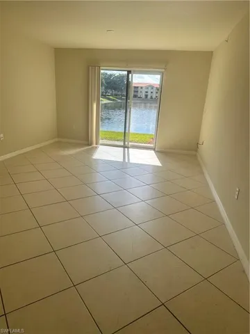 Unfurnished room featuring a water view and light tile patterned floors