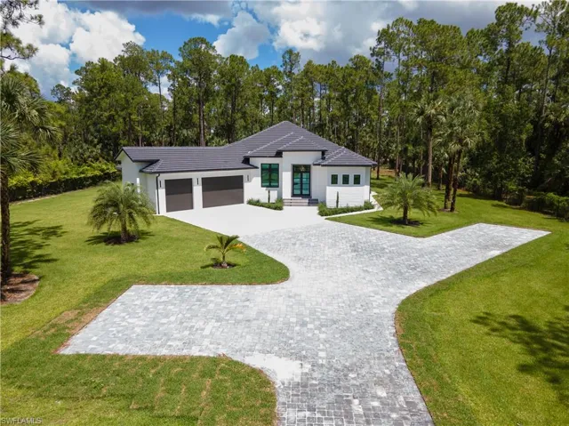 View of front of home with a front lawn and a garage