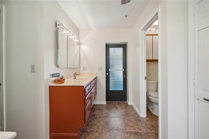 Bathroom with tile flooring, vanity, and toilet