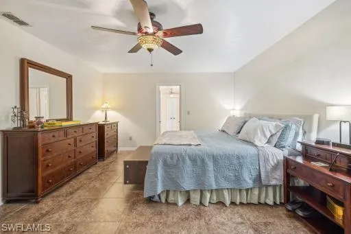Tiled bedroom featuring ceiling fan