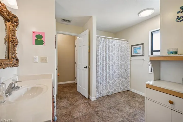 Bathroom featuring tile flooring and vanity with extensive cabinet space