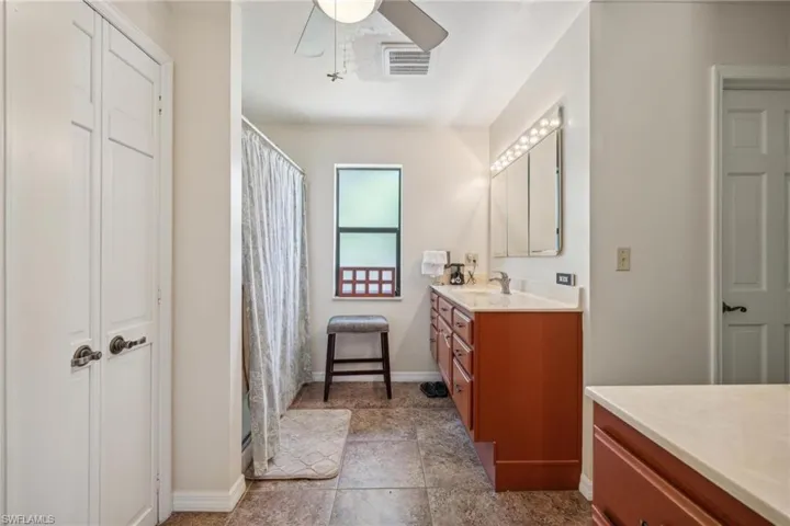 Bathroom featuring vanity, ceiling fan, and tile floors