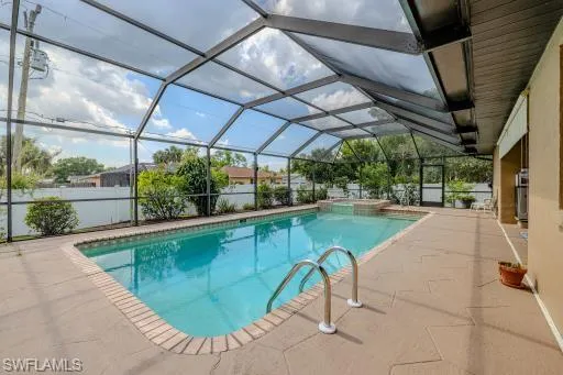 View of swimming pool featuring a patio and glass enclosure