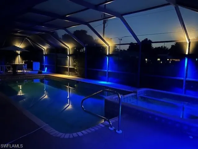 View of pool at night featuring a patio