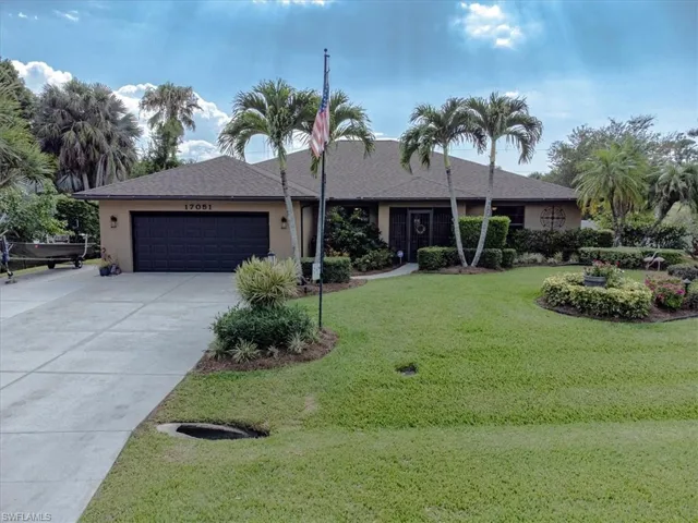 Ranch-style house featuring a two car garage and a front lawn