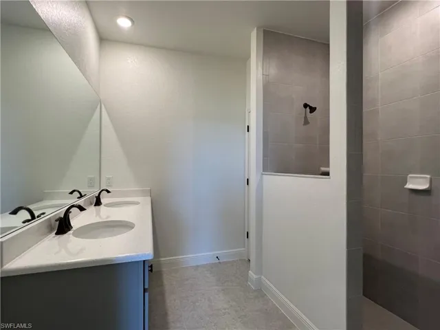 Full bath featuring double vanity and walk in shower