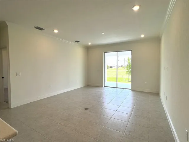 Empty room with crown molding, light tile patterned flooring, and recessed lighting