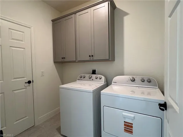 Laundry area featuring cabinet space and washing machine and dryer