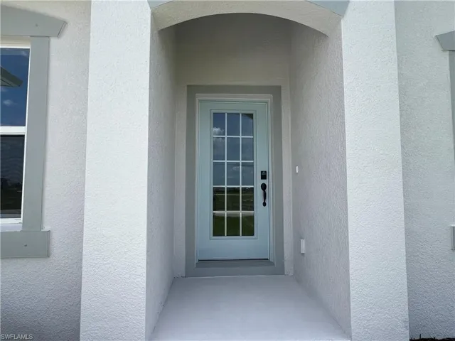 Entrance to property with stucco siding
