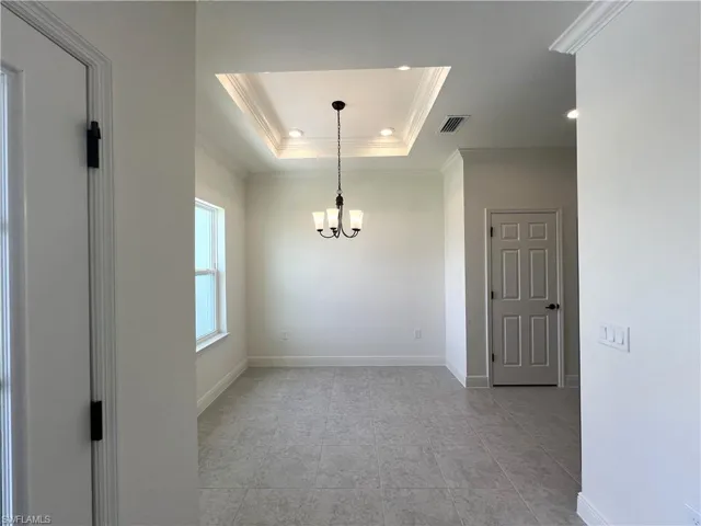 Unfurnished room with ornamental molding, a chandelier, recessed lighting, a raised ceiling, and light tile patterned flooring