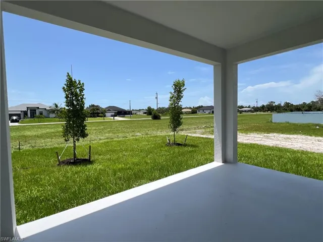 View of green lawn with a patio area