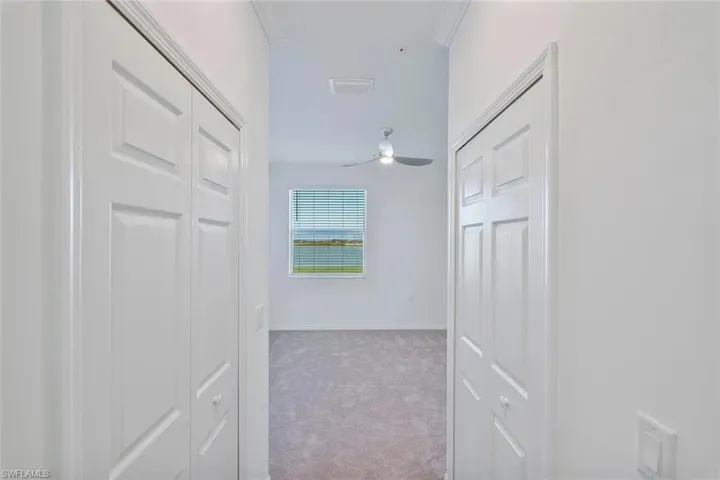 Hallway featuring two white bifold closet doors