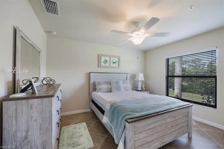 Tiled bedroom featuring ceiling fan
