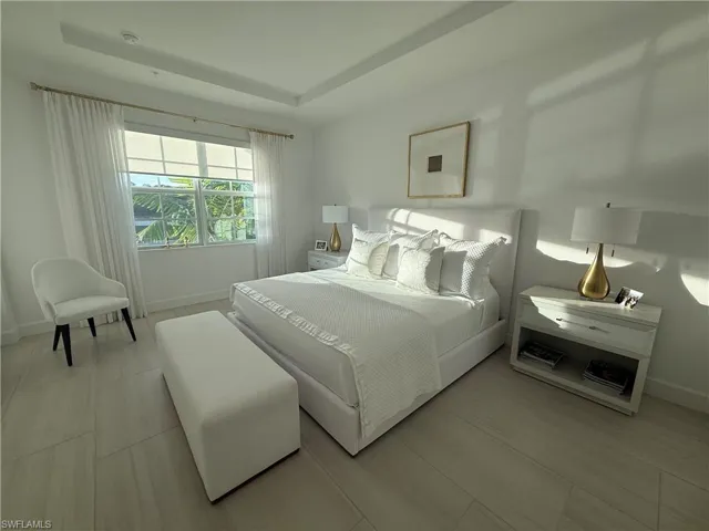 Bedroom featuring a raised ceiling and light wood finished floors