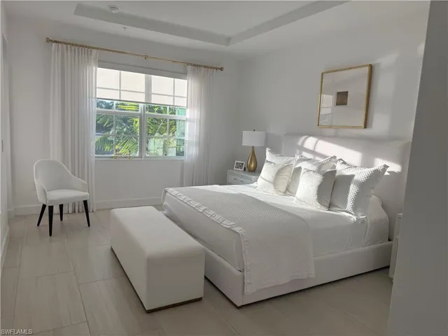 Bedroom with a tray ceiling and baseboards