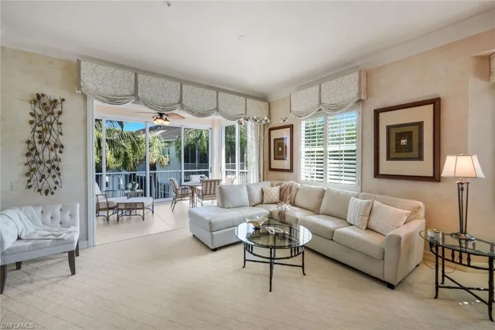 Living space featuring carpet flooring, decorative valances, and plantation shutters