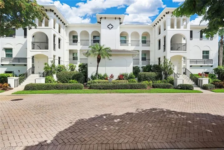 White stucco exterior with arched entryways and black railings