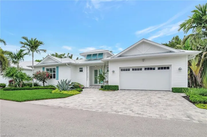 View of front facade with decorative driveway, a garage, and a front yard
