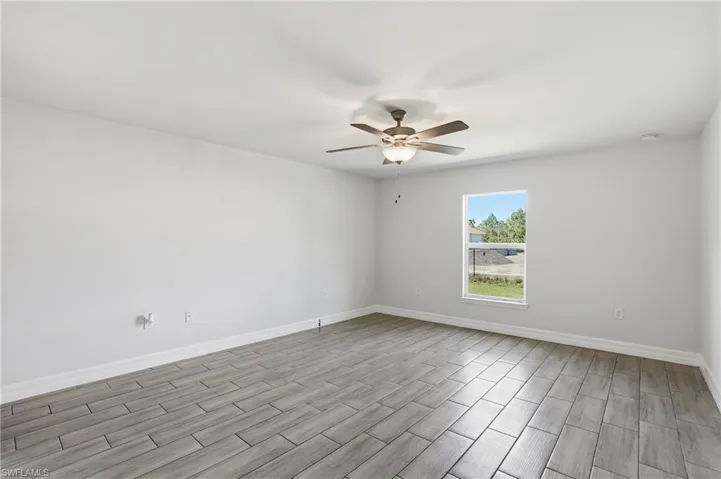 Unfurnished room featuring ceiling fan and wood finish floors