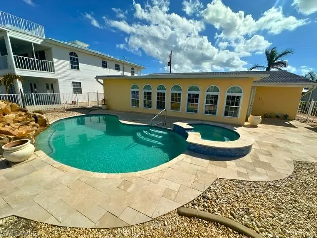 View of swimming pool featuring a patio and an in ground hot tub
