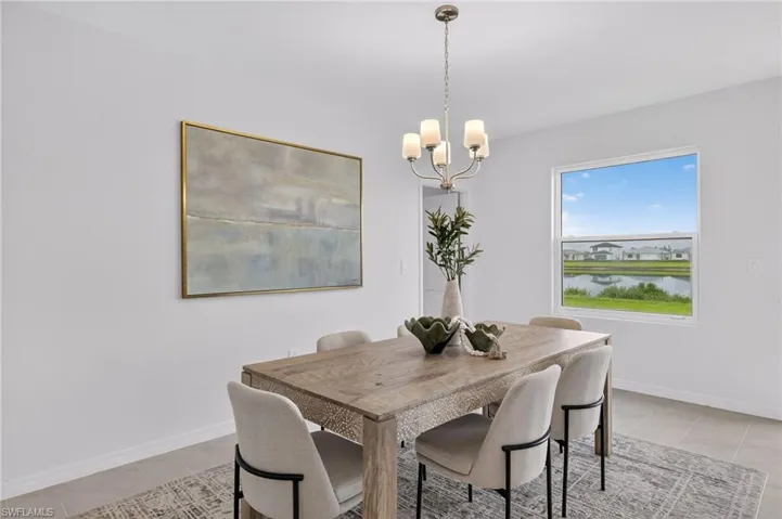 Dining area with a chandelier, light tile patterned floors, and a water view