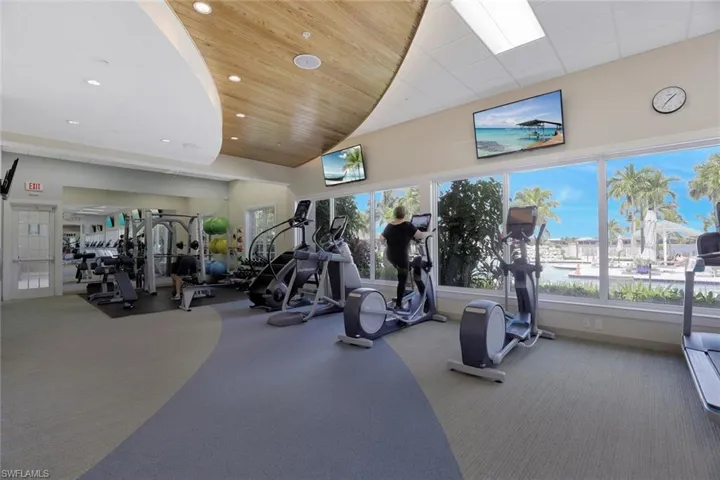 Gym featuring high vaulted ceiling and carpet floors