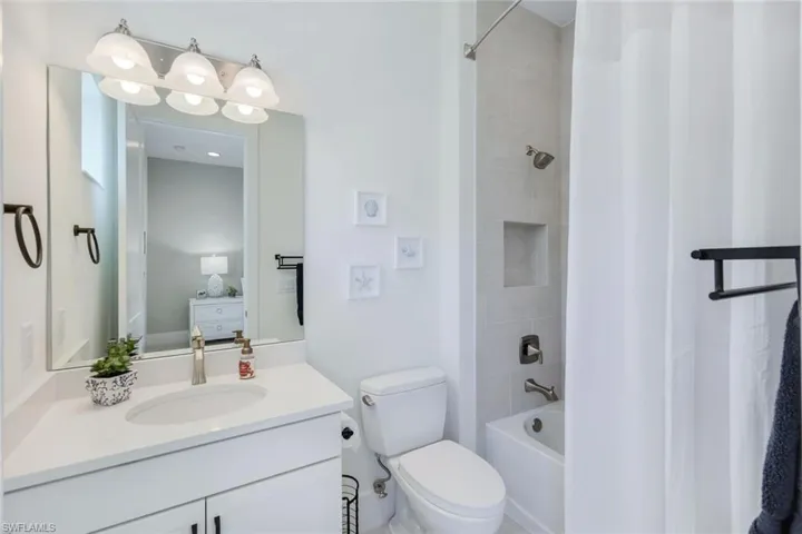 Full bathroom featuring shower / tub combo with curtain, vanity, and toilet